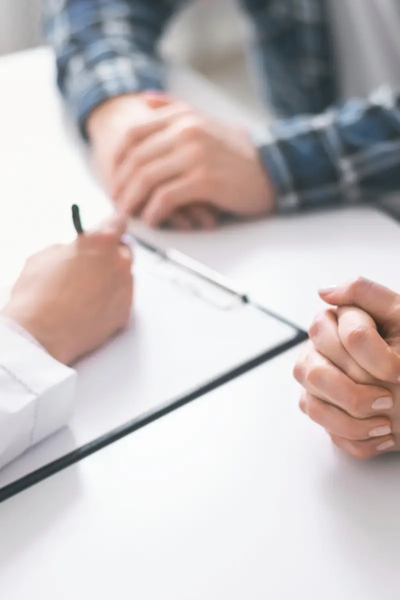 Medical consultation. Doctor writing prescription and treatment plan to couple of patients at clinic Medical consultation. Doctor writing prescription and treatment plan to couple of patients at clinic